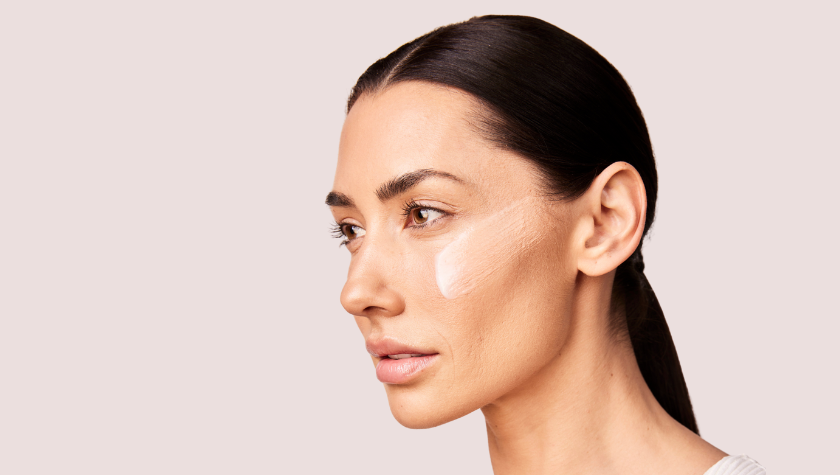 women with skin care product on her face